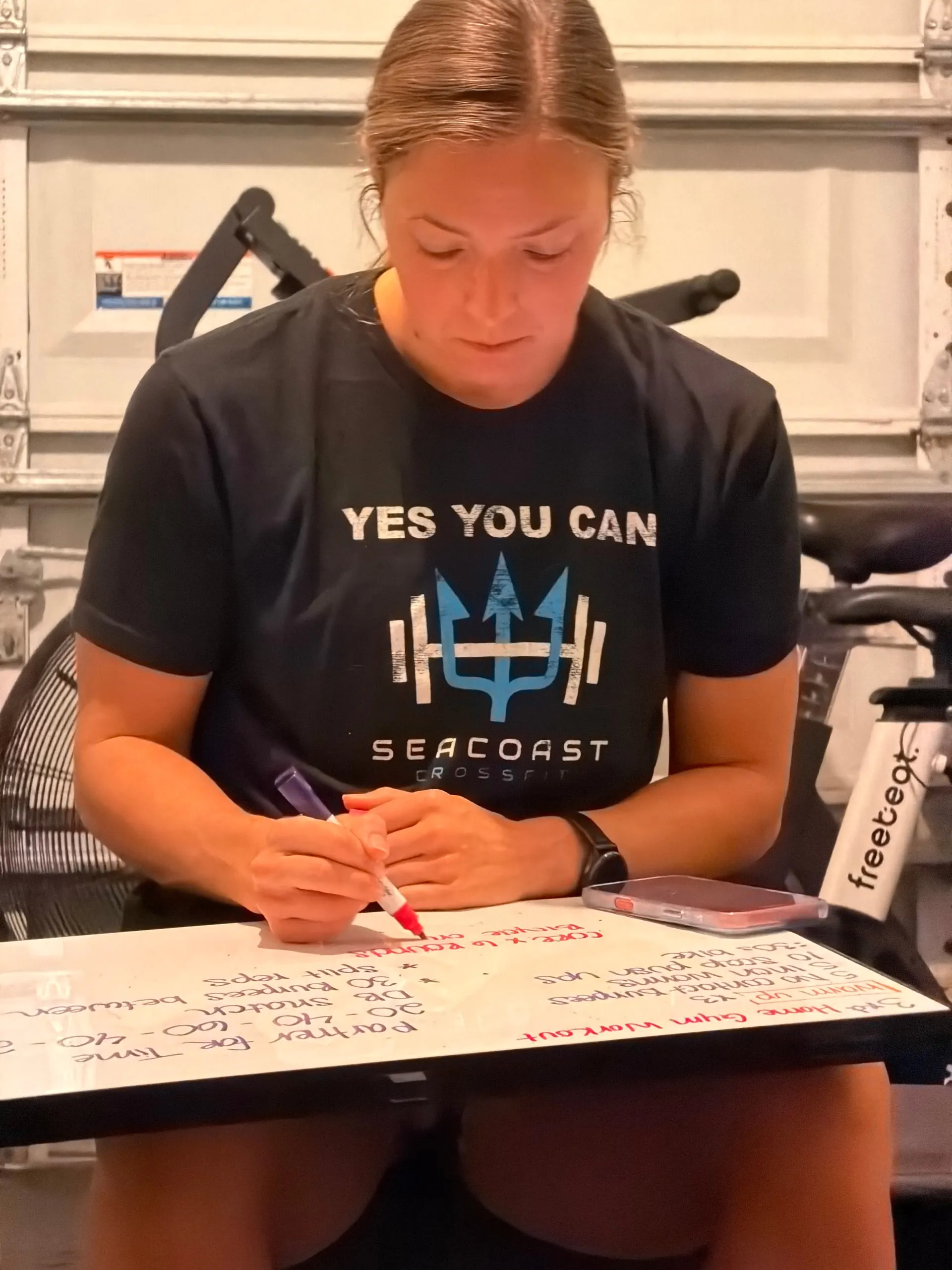 Lexi writing a training session out on a whiteboard